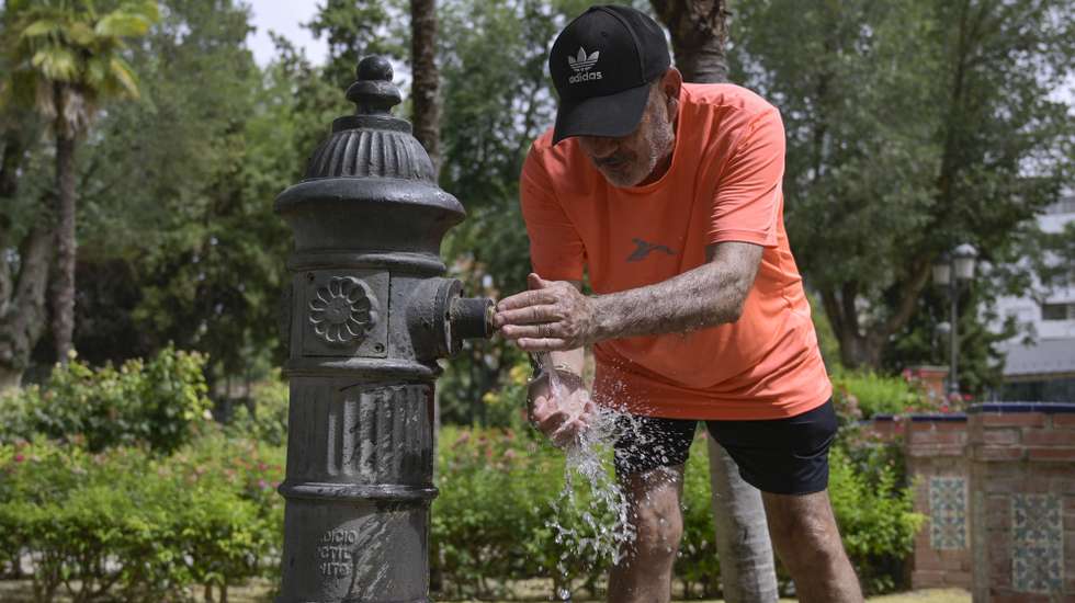 epa10791779 A man refreshes himself at a water fountain in Ciudad Real, Spain, 09 August 2023. Spain's current heat wave is forecasted to be in effect until 11 August according to meteorologists.  EPA/JESUS MONROY