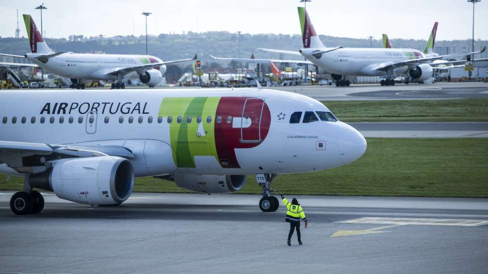 Um trabalhador de placa dá indicações a um piloto num avião da TAP, no Aeroporto Humberto Delgado, em Lisboa, 15 de abril de 2025.  JOSÉ SENA GOULÃO/LUSA