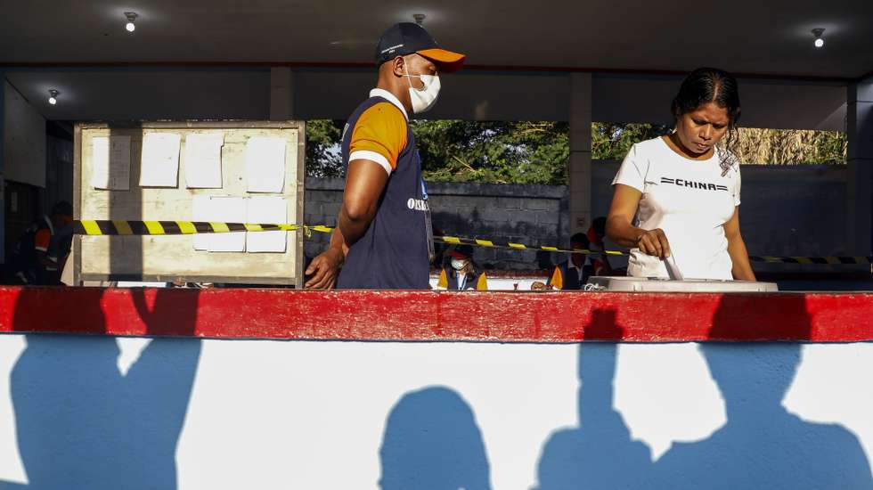 epa10642660 A woman casts her vote as an election officer looks on during the parliamentary election at a polling station in Dili, East Timor, also known as Timor Leste, 21 May 2023. Seventeen Parties are contesting in the fifth elections in East Timor scheduled for 21 May, which may take several days to be counted. More than 890,000 voters are registered for the vote, in which the 65 members of the National Parliament will be chosen.  EPA/ANTONIO DASIPARU