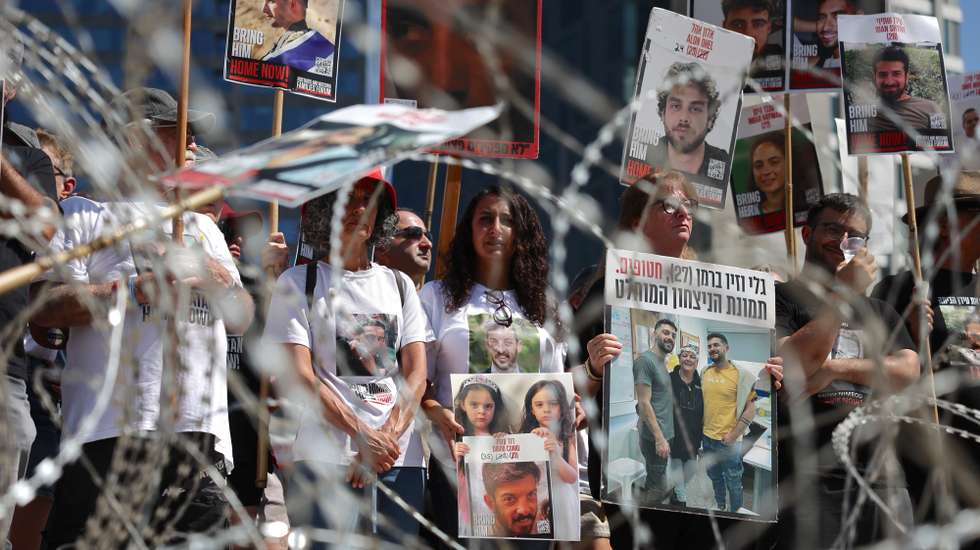 epaselect epa12278712 Families and supporters of Israeli hostages held by Hamas in Gaza hold pictures of the hostages near a barbed wire fence during a demonstration calling for a ceasefire and a hostage release deal, outside the Kirya military headquarters in Tel Aviv, Israel, 02 August 2025. The demonstration was sparked by recent footage released by Hamas reportedly showing Israeli hostages in dire conditions. According to Israel's military, around 50 Israeli hostages remain in captivity in the Gaza Strip, including the bodies of at least 30 confirmed dead.  EPA/ABIR SULTAN EPA