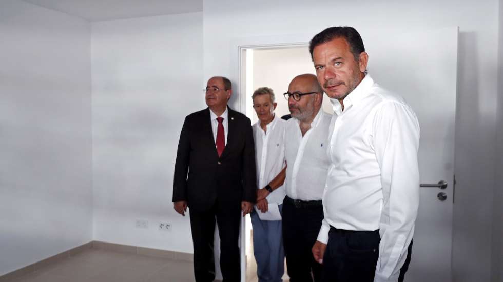 O primeiro-ministro, Luis Montenegro (D), acompanhado por Miguel Pinto Luz (2-D), ministro das Infraestruturas e Habitação, e por Rogério Bacalhau (E), presidente da câmara municipal de Faro, durante a inauguração de um conjunto habitacional na freguesia de Montenegro, no concelho de Faro, 12 de agosto de 2025. LUIS BRANCA/LUSA