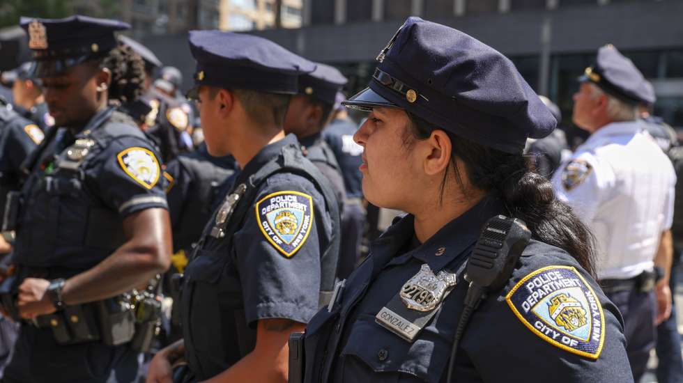 epa12294086 New York City police officers keep watch during a 'Rage Against The Regime March Against Immigration Cruelty' protest against the increase in immigrant detainments outside 26 Federal Plaza, which houses a US Immigration and Customs Enforcement (ICE) processing center, in New York, New York, USA, 11 August 2025. The US Department of Homeland Security is increasing recruitment and detainments to meet the Trump administration's goal of hiring 10,000 new ICE agents and deporting a million people a year.  EPA/SARAH YENESEL