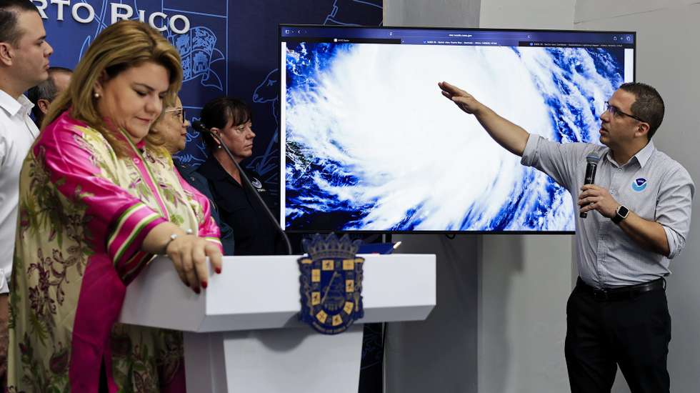 epa12307308 Puerto Rico Governor Jenniffer Gonzalez (L) listens to National Weather Service meteorologist Ernesto Rodriguez speaks (R) during a press conference at La Fortaleza (seat of government) in San Juan, Puerto Rico, 17 August 2025. Erin weakened during the early morning hours to a Category 3 hurricane on the Saffir-Simpson scale, with maximum sustained winds of 128 mph, while its outer bands brought heavy rains to Puerto Rico and the Virgin Islands, the NHC reported.  EPA/Thais Llorca