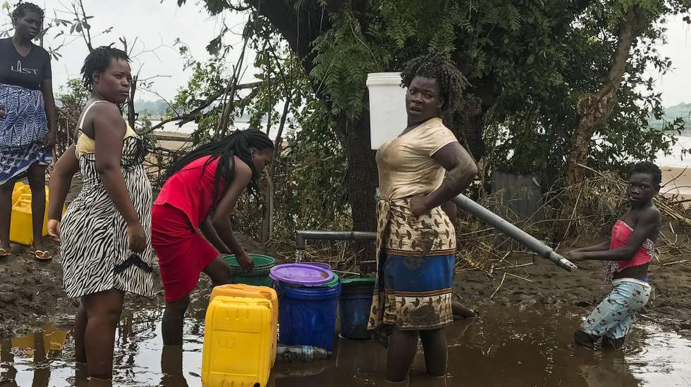 Mulheres retiram com baldes água de um poço para iniciarem as limpezas das casa inundadas pela tempestade tropical Ana. O número de mortes provocadas pela tempestade tropical Ana em Moçambique subiu para 20, segundo dados das autoridades locais e proteção civil, e a população vive por entre um rasto de destruição. A intempérie atingiu diretamente o país entre segunda e quarta-feira, mas apesar de já ter enfraquecido e avançado para outros países (Zimbabué e Zâmbia), as chuvas intensas alimentaram o caudal de todos os rios no centro e norte de Moçambique, que continuam a provocar inundações. Tete, Moçambique, 27 de janeiro de 2022. ANDRÉ CATUEIRA/LUSA