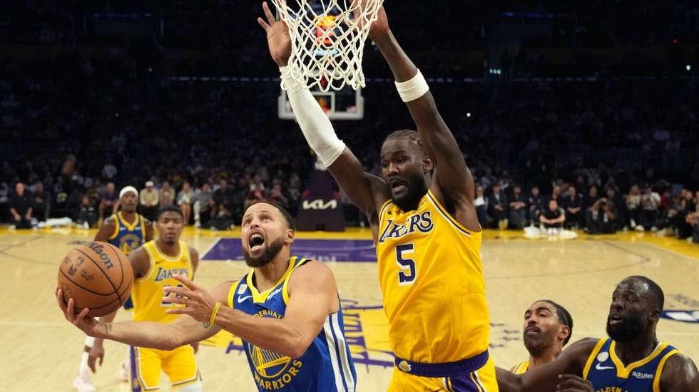 epa12471793 Golden State Warriors guard Stephen Curry (L) lays up the ball against Los Angeles Lakers center Deandre Ayton (R) during the first half of the NBA game between the Golden State Warriors and the Los Angeles Lakers in Los Angeles, California, 21 October 2025.  EPA/ALLISON DINNER SHUTTERSTOCK OUT