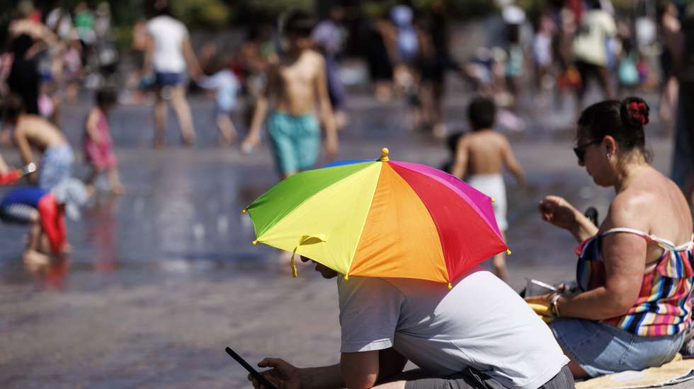 epa12995286 A person uses an umbrella to shelter from the sunshine at Granary Square during a heatwave in London, Britain, 26 May 2026. The record for the hottest May day on record in the UK is broken again with 35 Celsius degrees recorded in London during the heatwave. The UK Health Security Agency has issued an amber heat health alert for south-west England, bringing the number of amber alerts during the heatwave to six.  EPA/TOLGA AKMEN