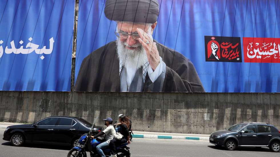 epaselect epa13077300 Iranians ride a motorbike past a large-scale poster of late Iranian Supreme Leader Ayatollah Ali Khamenei displayed along a highway, in Tehran, Iran, 01 July 2026. Iran is set to hold a multi-day state funeral from 04 to 09 July 2026 for late Iranian Supreme Leader Ayatollah Ali Khamenei, who was assassinated on 28 February.  EPA/ABEDIN TAHERKENAREH  -- RESTRICTIONS: NO Access Israel Media/Persian Language TV Stations Outside Iran/Strictly No Access BBC Persian/VOA Persian/Manoto TV/Iran International TV. (As mandated by Iran's Directorate General for Foreign Media) --