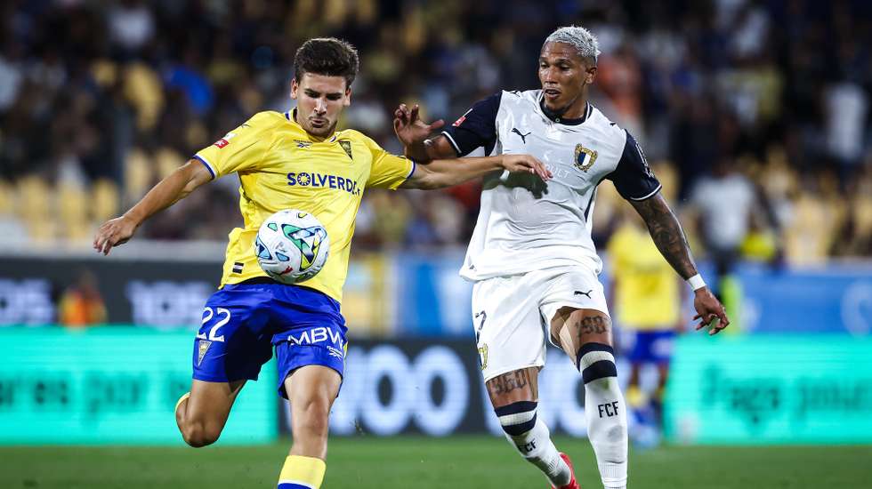 O jogador do Estoril Praia Pedro Carvalho (E), disputa a bola com o jogador do Famalicão Sorriso (D), durante o jogo da I Liga de futebol, realizado no Estádio António Coimbra da Mota, no Estoril, 7 de agosto de 2026. RODRIGO ANTUNES/LUSA