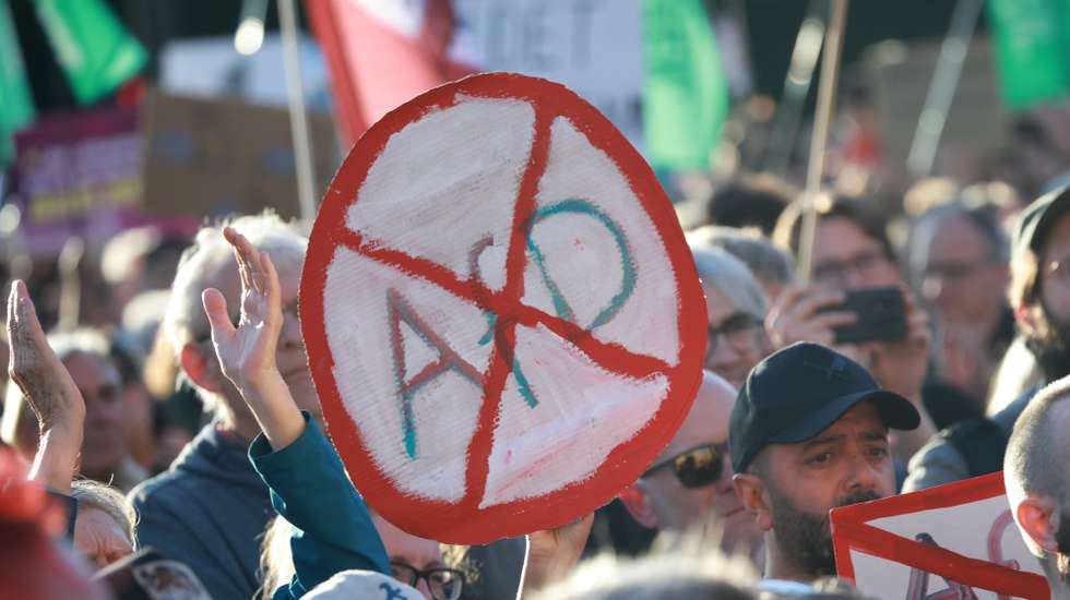 epa13220401 A participant holds a placard that resembles a road sign and shows a crossed out AfD during a rally at the Brandenburg Gate in Berlin, Germany, 07 September 2026. The protest was scheduled a day after the far-right Alternative for Germany party (AfD) won the election in the regional state of Saxony Anhalt by a wide margin.  EPA/CLEMENS BILAN