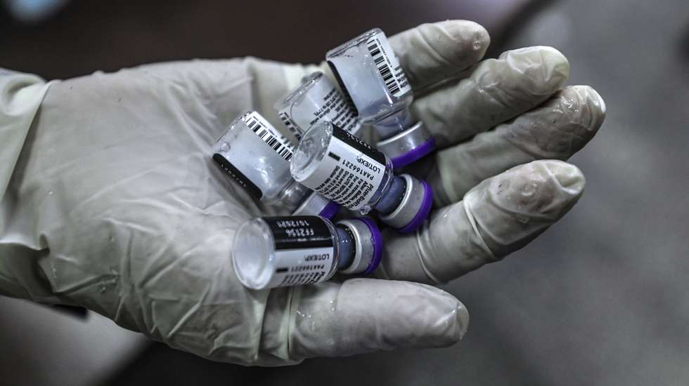 epa09440265 A Palestinian medic holds vials of Pfizer-BioNTech COVID-19 vaccines at the high school of Khalil Al Wazir in Gaza, 01 September 2021. The Palestinian government launched a campaign to vaccinate school students in West Bank and Gaza to prevent increasing infections with Covid-19.  EPA/MOHAMMED SABER