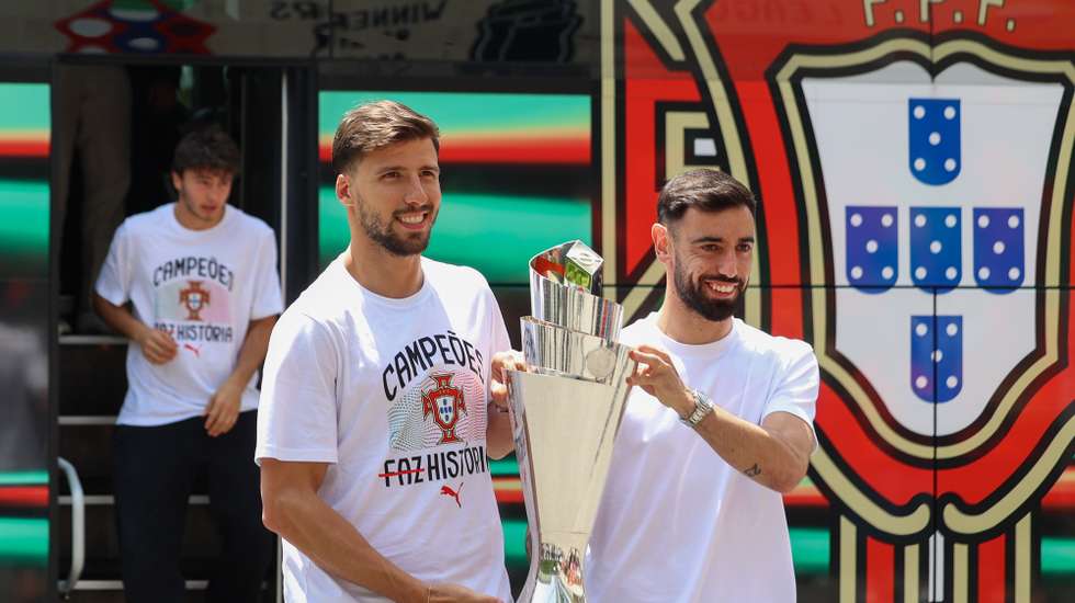 Ruben Dias (E) e Bruno Fernandes seguram a taça conquistada ontem pela segunda vez na Liga das Nações de futebol, ao bater na final a Espanha por 5-3 no desempate por grandes penalidades, Cidade do Futebol, Oeiras, 9 de junho de 2025. TIAGO PETINGA/LUSA