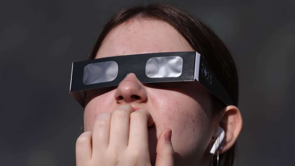 epa11996675 A woman uses protective glasses to watch a partial solar eclipse, at Greenwich Observatory in London, Britain, 29 March 2025. A solar eclipse happens when the Moon passes between the Sun and Earth, casting a shadow on Earth that either fully or partially blocks the Sun’s light in some areas.  EPA/NEIL HALL
