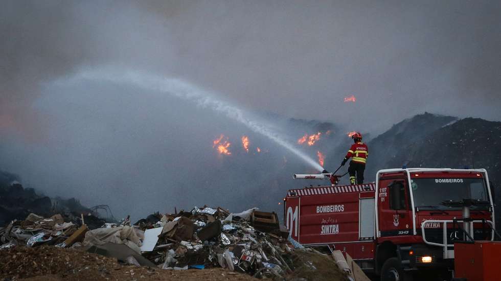 Um bombeiro combate um incêndio que deflagrou hoje à tarde na empresa Tratolixo, em Trajouce, no concelho de Cascais, 10 de julho de 2021. De acordo com fonte do Comando Distrital de Operações de Socorro (CDOS) de Lisboa, o alerta para o fogo na empresa de tratamento de resíduos sólidos Tratolixo, que entretanto se estendeu a uma zona de mato, foi dado às 16:15 e às 20:30 segundo a Autoridade Nacional de Emergência e Proteção Civil estão no terreno 154 operacionais , apoiados por 56 veículos. RODRIGO ANTUNES/LUSA