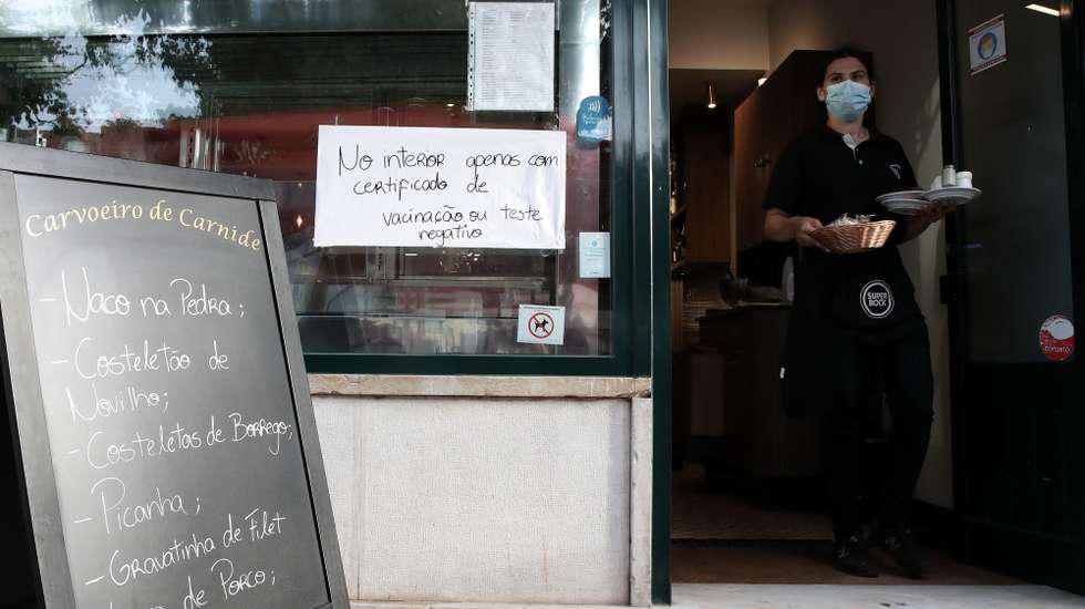 Aviso sobre certificado digital ou teste à entrada de um restaurante em Lisboa, após o Governo decreta que os restaurantes em concelhos de risco elevado ou muito elevado – um total de 60 – passam a ter de exigir certificado digital ou teste negativo à covid-19 a partir das 19:00 de sexta-feira e aos fins de semana para refeições no interior, Lisboa, 10 de julho de 2021. As pessoas em esplanadas que precisarem de entrar nos restaurantes para acesso aos serviços comuns, como instalações sanitárias, ou para efetuarem pagamento, estão dispensadas de apresentar um teste negativo à covid-19 ou o certificado digital. MANUEL DE ALMEIDA/LUSA