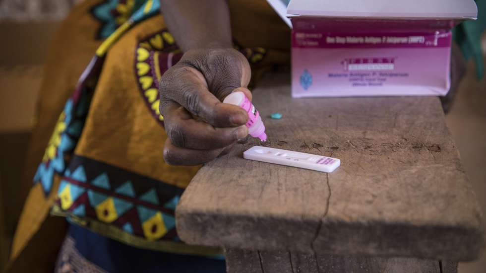 Uma técnica de saúde faz o teste à malária durante uma consulta de uma brigada móvel do Fundo das Nações Unidas para a Infância (UNICEF), um grupo de profissionais de saúde que viaja de ambulância e vai ao encontro das comunidades mais afastadas em vez de esperar por elas em centros de saúde, Impire, Moçambique, 24 de julho de 2020. Em menos de uma hora, na povoação de Impire, distrito de Metuge, sul de Cabo Delgado, juntam-se dezenas de mães com as suas crianças - a maioria ainda bebés - para a brigada observar, com pesagem, medição de altura, avaliação à subnutrição, seguindo-se uma consulta, vacinação e entrega da medicamentos numa rotina que inclui a observação das mães e decorre desde manhã até o sol se pôr, num pavilhão empoeirado. (ACOMPANHA TEXTO DE 25 DE JULHO DE 2020). RICARDO FRANCO/LUSA