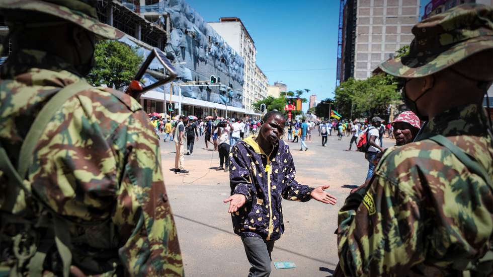 Um manifestante conversa com militares durante uma marcha de contestação das eleições de 09 de outubro em Maputo, Moçambique, 29 de novembro de 2024. LUÍSA NHANTUMBO/LUSA