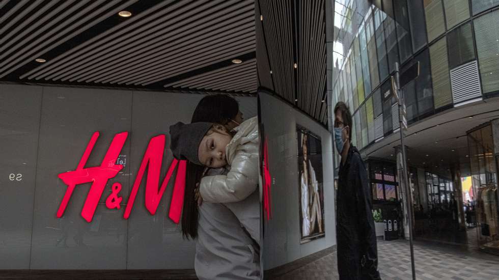 epa09100724 A woman with a child walks past H&amp;M store in a shopping area of Sanlitun, in Beijing, China, 27 March 2021. After H&amp;M and Nike, many other international clothing brands face backlash in China for refusing to buy Xinjiang cotton over claims of forced labor and repressions against Uighurs in the region.  EPA/ROMAN PILIPEY