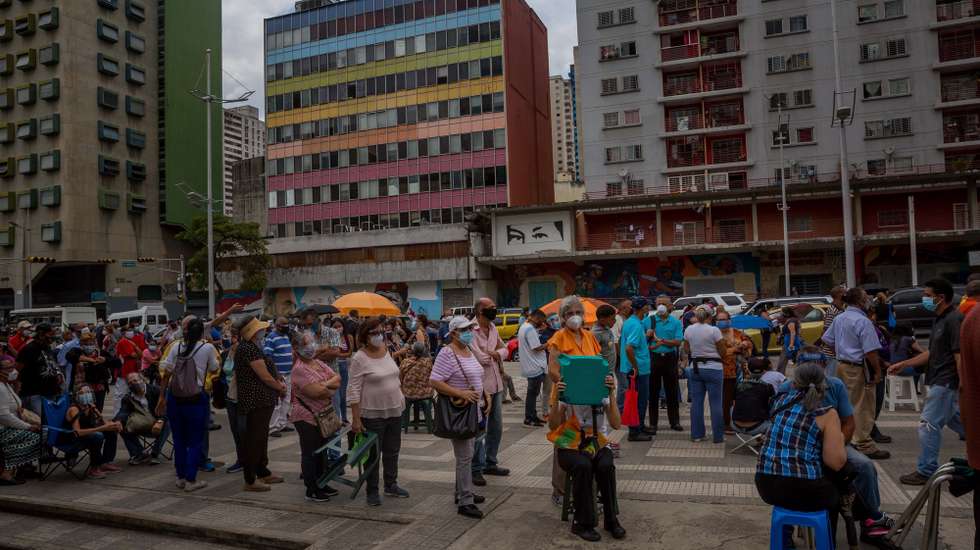 epa09249723 Dozens of people wait outside a COVID-19 vaccination center in Caracas, Venezuela, 02 June 2021 (Issued 05 June 2021). Hundreds of Venezuelans went this week to the vaccination points established by the government, waiting to be vaccinated. The system, which started in a 'controlled' way, became, with the passing of days, in disorder.  EPA/MIGUEL GUTIERREZ
