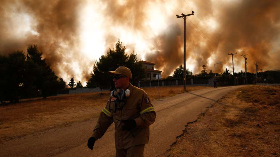 epa09398563 A fireman battles to extinguish a wildfire  a wildfire in the area of Drossopigi, Varybobi, northeastern suburb of Athens, Greece, 05 August 2021. More firefighters and support by air have been added to the forces battling the resurgence of the fire in Varybobi, north of Athens. A total of nine helicopters and four airplanes are dropping water on the fire, which is out of control. Police has blocked traffic on all roads leading to Varibobi and fire fronts, near the former royal estates in Tatoi. The rekindling of the fire, aided by heatwave temperatures and winds, has led to the evacuations of Ippokratios Politia and Drossopigi.  EPA/YANNIS KOLESIDIS