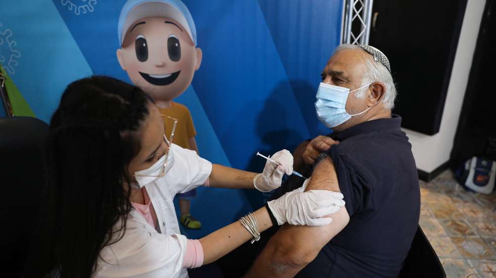 epa09409493 A nurse injects a man with a third shot of COVID-19 vaccine in Jerusalem, Israel, 11 August 2021. Israel launched a campaign to offer a third Covid-19 vaccine dose for people over 60 who received a second shot at least five months ago after infections were reportedly increasing in the country. According to reports, the number of infections in Israel rose above 6,000 per day.  EPA/ABIR SULTAN