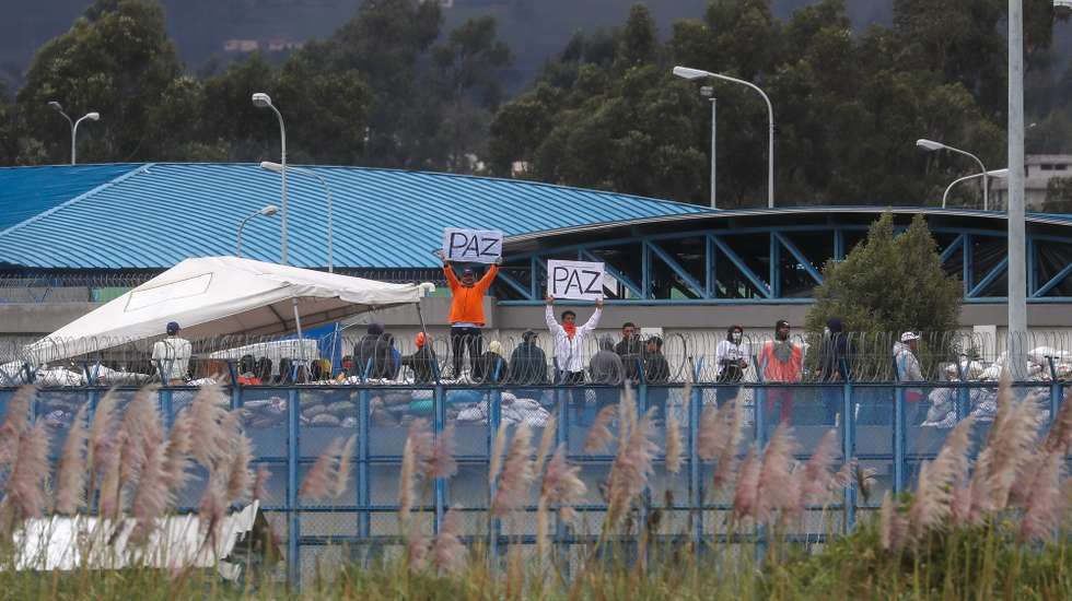 epa11068283 Inmates hold up signs as they remain on the roof of the Sierra Centro Norte Cotopaxi Social Rehabilitation Center, in Latacunga, Ecuador, 10 January 2024. The President of Ecuador, Daniel Noboa, assured that his country is in a state of war after the violent actions carried out by organized crime gangs that led him to declare internal armed conflict, and he said that he does not plan to negotiate or give in to these groups, which his government has described as "terrorists".  EPA/Jose Jacome