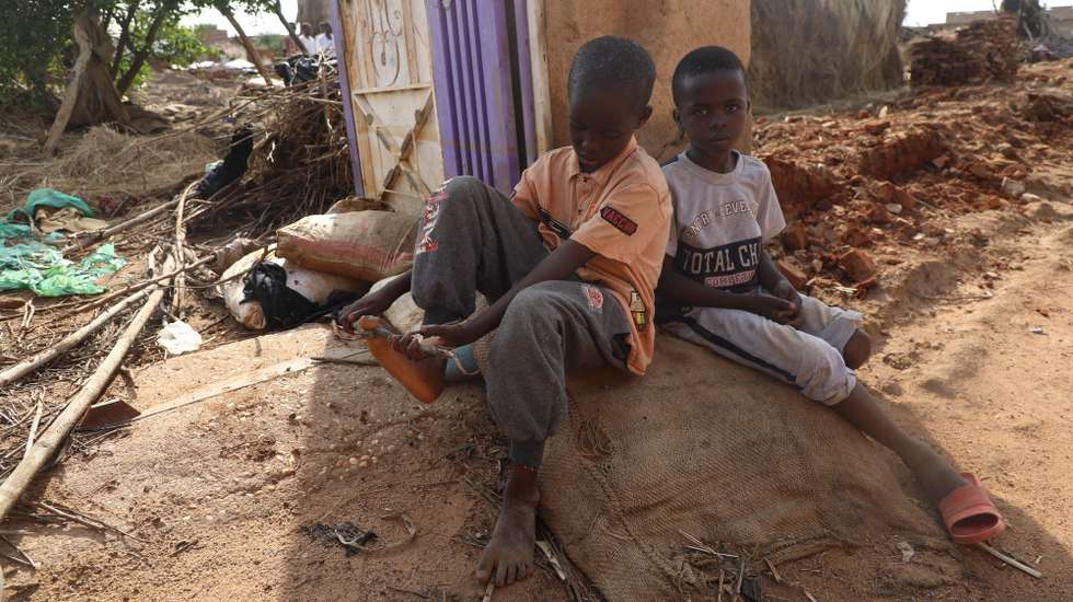 epa10135168 Sudanese children sit near a damaged house at a flooded area of Al Jazirah state, Sudan, 23 August 2022. According to the Sudanese Council for Civil Defense, at least 79 people died in incidents related to the recent floods in the country. Thousands of homes were damaged due to the floods that affected South Darfur, North Kordofan, and Al Jazirah state.  EPA/MOHND AWAD