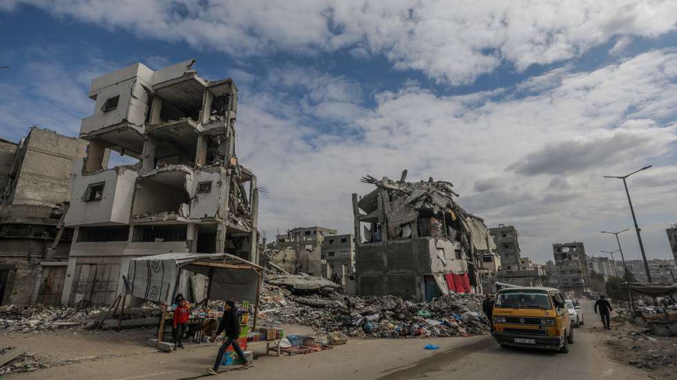 epa11882776 Palestinians walk past destroyed houses amid a ceasefire between Israel and Hamas, in Gaza City, 08 February 2025. Israel and Hamas implemented the first phase of a hostage release and ceasefire deal on 19 January 2025. More than 48,000 Palestinians have been killed in the Gaza Strip, according to the Palestinian Ministry of Health, since Israel launched a military campaign in the strip in response to a cross-border attack led by the Palestinian militant group Hamas on 07 October 2023, in which about 1,200 Israelis were killed and more than 250 taken hostage.  EPA/MOHAMMED SABER