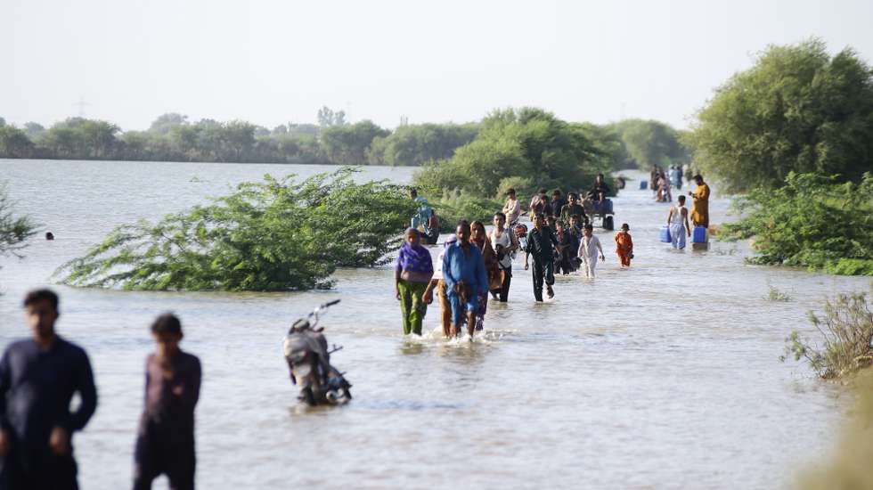epa12398383 Locals in Unnar Pur wade through floodwater in Hyderabad, Pakistan, 22 September 2025. Floodwaters have surrounded Unnar Pur, Manzoorabad, and Budha Pur near Jamshoro, leaving several villages completely submerged.  EPA/NADEEM KHAWAR