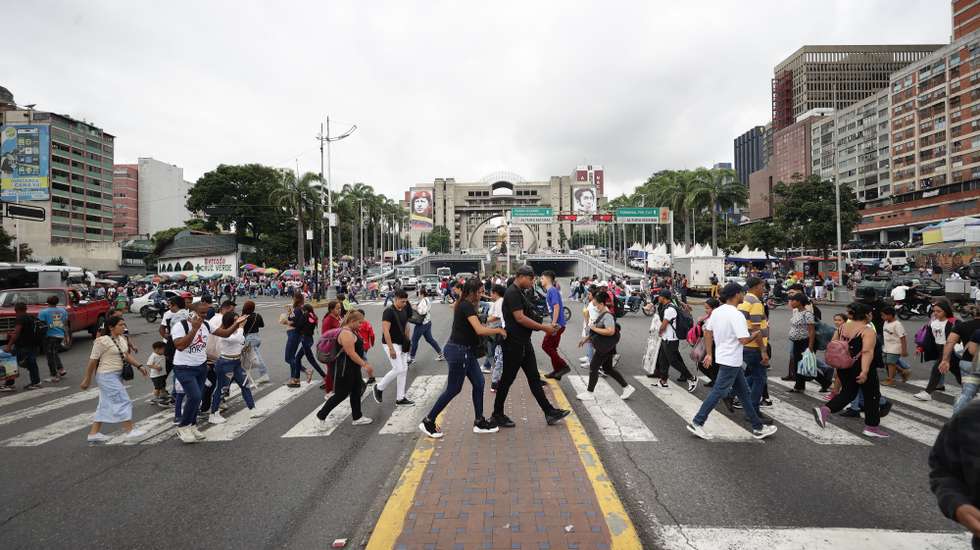 epa12558079 People walk down a street in Caracas, Venezuela, 29 November 2025.  EPA/Ronald Pena R