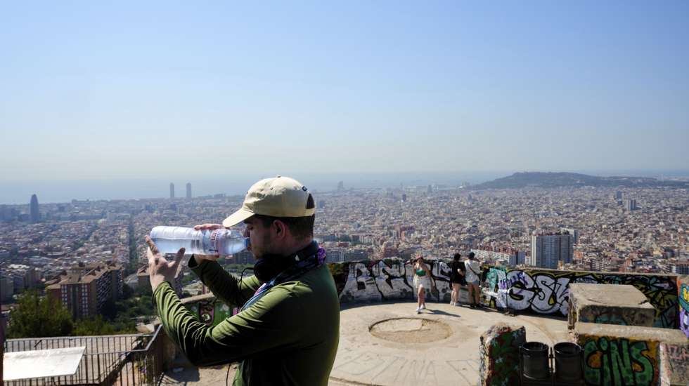epa12206074 A tourist drinks water at Turo de la Rovira spot in Barcelona, northeastern Spain, 30 June 2025. Several Spanish regions are on alert for exceptionally high temperatures as the first heat wave of the summer hits the country.  EPA/ALEJANDRO GARCIA