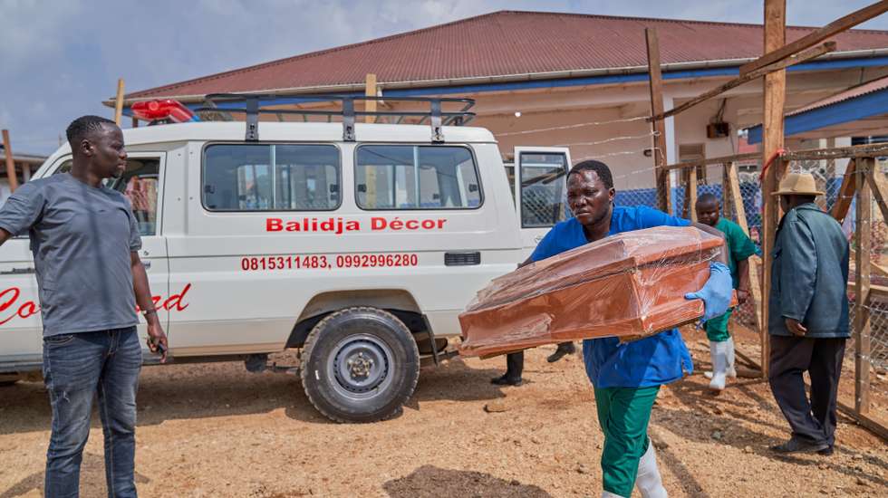 epa13127206 A staff member carries a small size coffin at the Ebola treatment center of the General Hospital in Bunia, Ituri province, Democratic Republic of Congo, 22 July 2026. According to the World Health Organization (WHO), the province of Ituri remains the epicenter of the Bundibugyo variant of the Ebola virus, reaching almost 1000 deaths.  EPA/DIEUDONNE DIROLE