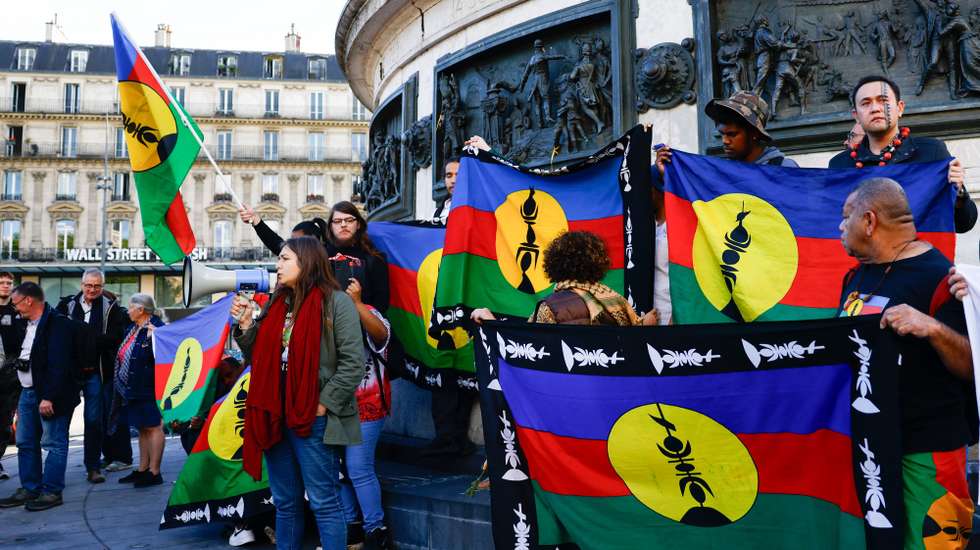 epa11346098 Protesters hold Kanak flags as they participate in a rally called by Caledonian activists in solidarity with Kanak people, at Place de la Republique in Paris, France, 16 May 2024. The French territory of New Caledonia has experienced three nights of clashes in response to a reform to electoral procedures, which the indigenous Kanak population believes will diminish their vote. France has declared a state of emergency and deployed its military to the territory's ports and international airport in response to the unrest, which has resulted in at least four deaths and hundreds of wounded.  EPA/MOHAMMED BADRA