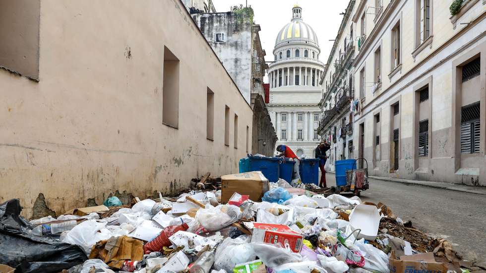 epa11076691 People search through garbage containers a block away from the National Capitol Building in Havana, Cuba, 11 January 2024 (issued 14 January 2024). Divers, locally known as ‘buzos’, searching through garbage tanks are an increasingly common sight in Havana and other Cuban cities, where three years of serious economic crisis are taking a dramatic social toll.  EPA/YANDER ZAMORA