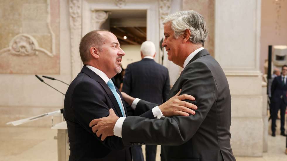 O novo governador do Banco de Portugal (BdP), Álvaro Santos Pereira (E), é cumprimentado pelo seu antecessor, Mário Centeno (D), na cerimónia de apresentação pública no Museu do Dinheiro, em Lisboa, 06 de outubro de 2025. JOÃO RELVAS/LUSA