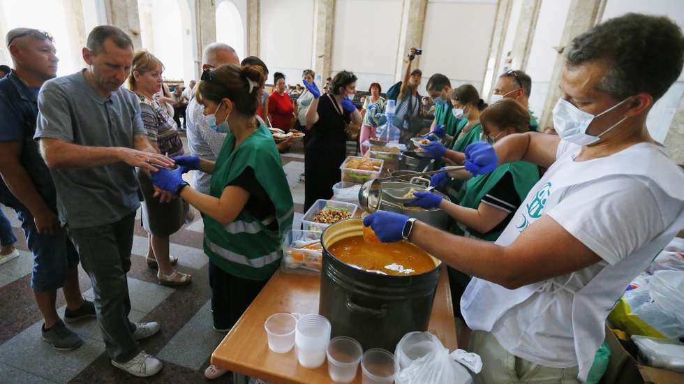epa09991724 Evacuees from Mykolayiv receive humanitarian food assistance as they wait at a railway station in Odesa, southwestern Ukraine, 02 June 2022, before traveling to the west of Ukraine or other countries. Mykolayiv authorities called on locals to leave some regions of the city amid the Russian invasion. Russian troops on 24 February entered Ukrainian territory, starting a conflict that has provoked destruction and a humanitarian crisis. According to the United Nations High Commissioner for Refugees (UNHCR), more than 6.8 million refugees have fled Ukraine, and a further 7.7 million people have been displaced internally within Ukraine since.  EPA/STEPAN FRANKO