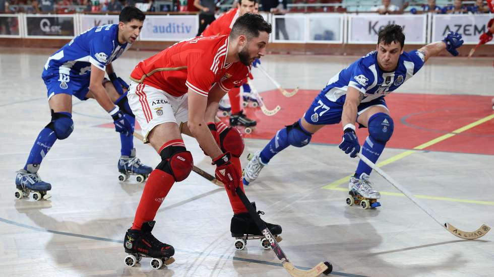 O jogador do Benfica, Roberto di Benedetto (C), em ação contra o jogador do FC Porto, Gonçalo Alves (D), durante o jogo do Campeonato Nacional de hóquei em patins, play-off, no pavilhão da Luz, em Lisboa, 26 de junho de 2024. MANUEL DE ALMEIDA/LUSA