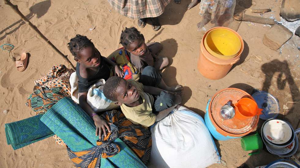 Crianças no Centro de Trânsito de Namissir, na Escola Primária Completa dos Coqueiros, que alberga mais de 5.000 famílias deslocadas devido a ataques de grupos armados em Chiúre, na província de Cabo Delgado, norte de Moçambique, 29 de julho de 2025. Uma mulher cozinha acompanhada de duas crianças no Centro de Trânsito de Namissir, na Escola Primária Completa dos Coqueiros, que alberga mais de 5.000 famílias deslocadas devido a ataques de grupos armados em Chiúre, na província de Cabo Delgado, norte de Moçambique, 29 de julho de 2025. Vários distritos de Cabo Delgado, sobretudo Chiúre, estão a registar uma crescente atividade por parte de elementos destes grupos nos últimos dias. Na semana passada, extremistas reivindicarem também a decapitação, em locais diferentes, de pelos menos três cristãos moçambicanos. (ACOMPANHA TEXTO DA LUSA DO DIA 09 DE AGOSTO DE 2025). LUÍSA NHANTUMBO