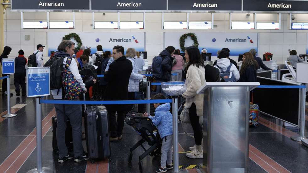 epa12610144 Travellers stand in line at Ronald Reagan Airport in Arlington, Virginia, USA, 23 December 2025. The American Automobile Association (AAA) estimates 122.4 million people in the United States will travel at least 50 miles for this years Christmas and New Year’s holidays.  EPA/WILL OLIVER
