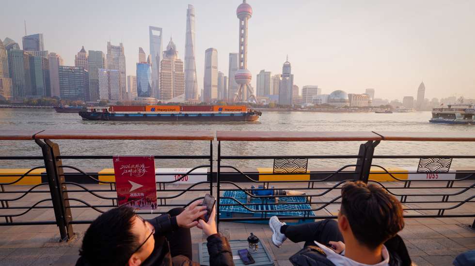 epaselect epa12647827 People in cafe watch cargo ships passing by on Huangpu River, in Shanghai, China, 13 January 2026 (issued 14 January 2026). According to the General Administration of Customs, China’s trade surplus reached a record $1 trillion in the first 11 months of the year, with exports rising 5.4 percent and imports falling 0.6 percent; the November surplus stood at $112 billion, the third largest on record.  EPA/ALEX PLAVEVSKI