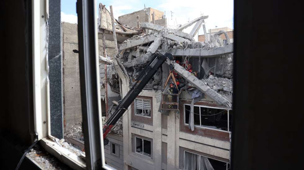 epa12853800 Iranian firefighters try to recover a body stuck under the rubble of a residential building in southern Tehran, Iran, 27 March 2026. A joint Israeli and US military operation continues to target multiple locations across Iran since the early hours of 28 February 2026.  EPA/ABEDIN TAHERKENAREH