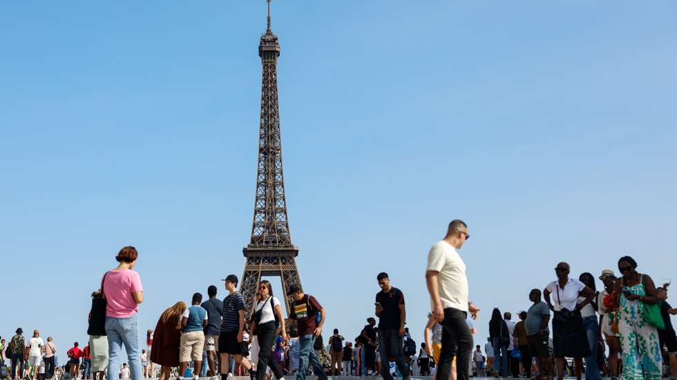 epa12292689 People walk on the Esplanade de Trocadero in front of the Eiffel Tower during a heatwave in Paris, France, 10 August 2025. France experiences high temperatures across the country.  EPA/MOHAMMED BADRA