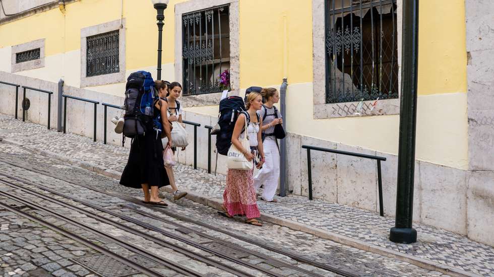 Turistas observam o local onde se deu o descarrilamento seguido de queda livre e colisão do histórico elevador da Glória, durante a homenagem às vítimas do acidente no elevador da Glória, organizada pelo Sindicato dos Trabalhadores de Transportes Rodoviários e Urbanos de Portugal, filiado na Federação dos Sindicatos de Transportes e Comunicações, em Lisboa, 03 de setembro de 2026. O histórico ascensor descarrilou a 03 de setembro de 2025, provocando 16 mortos e 24 feridos, de 15 nacionalidades. JOSÉ SENA GOULÃO/LUSA