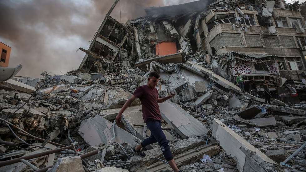 epa09195418 Palestinians inspect the rubble of the destroyed Al-Shorouq tower after an Israeli strike in Gaza City, 12 May 2021. In response to days of violent confrontations between Israeli security forces and Palestinians in Jerusalem, various Palestinian militants factions in Gaza launched rocket attacks since 10 May that killed at least six Israelis to date. Gaza Strip's health ministry said that at least 65 Palestinians, including 13 children, were killed in the recent retaliatory Israeli airstrikes. Hamas confirmed the death of Bassem Issa, its Gaza City commander, during an airstrike.  EPA/MOHAMMED SABER