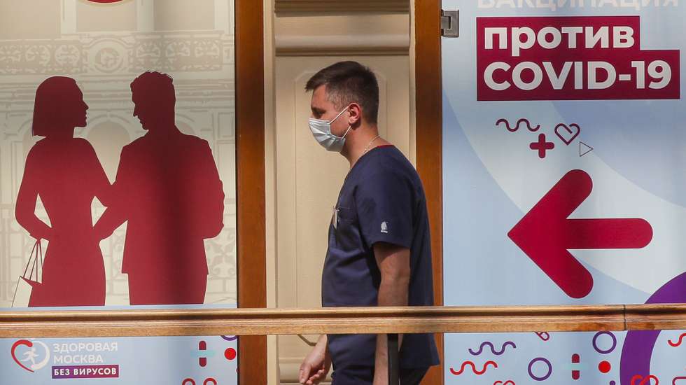 epa09282548 A man wearing a face mask passes the vaccination point at the State Department Store GUM in Moscow, Russia, 18 June 2021. Over the past 24 hours, 9,056 cases of COVID-19 coronavirus infection have been detected in Moscow, which has become a new absolute record since the beginning of the pandemic.  Mass entertainment events with more than 1,000 participants are prohibited in Moscow, while dance floors and fan zones for football fans are being closed.  EPA/SERGEI ILNITSKY