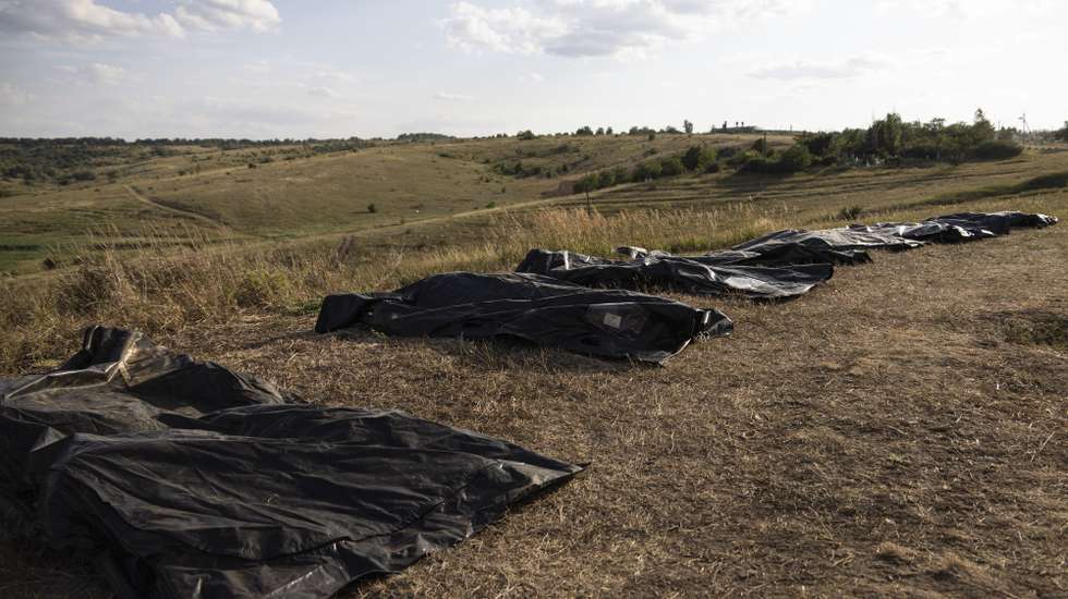 epa11517596 Body Bags are lined up on a field as members of Ukraine’s 'Platsdarm' search group (not pictured) work on exhuming and identifying the bodies of dead Russian servicemen near a frontline in the Bakhmut area, Donetsk region, Ukraine, 01 August 2024 (issued 02 August 2024), amid the Russian invasion. The 'Platsdarm' group searches for the bodies of Russian soldiers, documenting and collecting clues that would allow IDing them, and hand them over to the Russian side in exchange for Ukrainian soldiers' bodies.  EPA/NIKOLETTA STOYANOVA