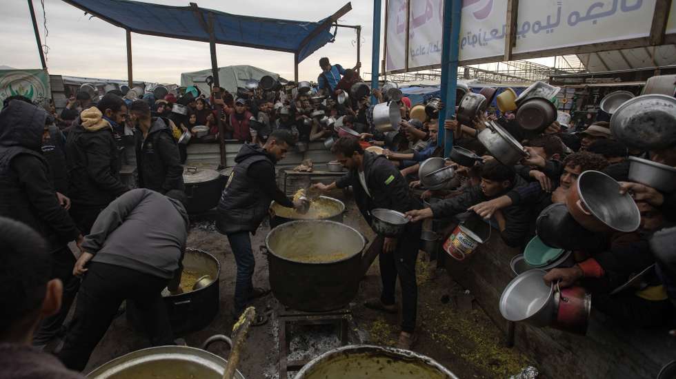 epa11747355 Palestinians, including children, hold metal pots and pans as they gather to receive food cooked by a charity kitchen, in Khan Yunis, southern Gaza Strip, 29 November 2024. According to the UN Palestinian refugee agency UNRWA, over 1.8 million people across the Gaza Strip are experiencing 'high levels' of acute food insecurity, including around 133,000 people facing 'catastrophic' food insecurity, with acute malnutrition ten times higher than before the war. According to the UN, at least 1.9 million people (or nine in ten people) across the Strip are internally displaced, including people who have been repeatedly displaced. Since October 2023, only about 11 percent of the Palestinian enclave has not been placed under Israeli-issued evacuation orders, the UN aid coordination office OCHA said.  EPA/HAITHAM IMAD