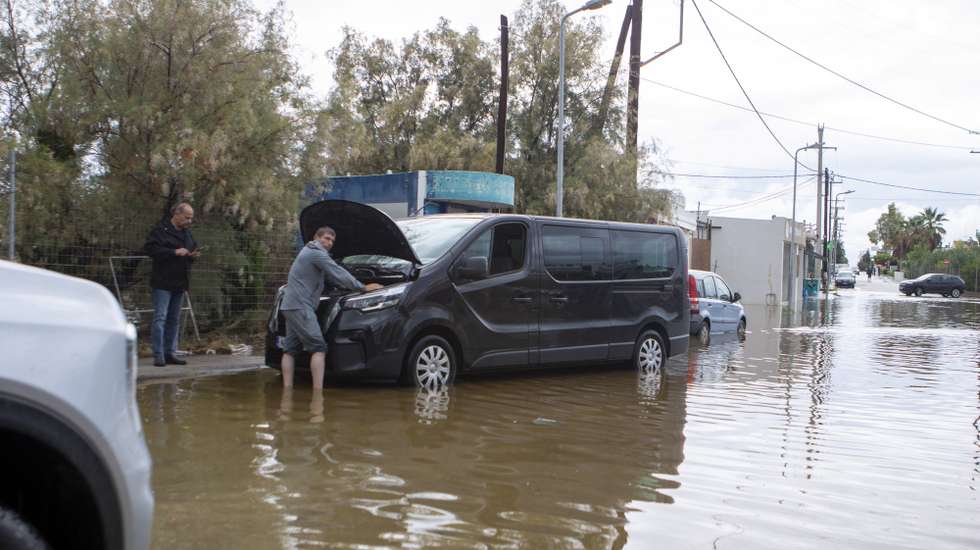 epa13303967 A man attempts to repair his car following severe weather in Rhodes, Greece, 14 October 2026. Heavy rainfall, thunderstorms and gale-force winds have caused flooding and traffic disruptions across several parts of Greece. According to the Athens-Macedonia News Agency (AMNA), Coast Guard personnel recovered the body of a man whose car was swept into the sea at Stegna Beach in Archangelos, Rhodes.  EPA/LEFTERIS DAMIANIDIS
