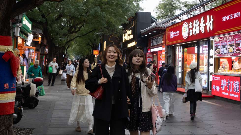 epa13321827 People walk on a street in a touristic area in Beijing, China, 22 October 2026.  EPA/JESSICA LEE