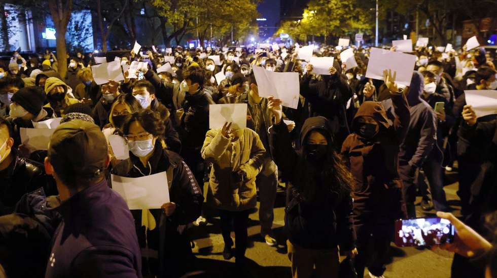 epaselect epa10332665 Protesters hold blank white pieces of paper during a protest triggered by a fire in Urumqi that killed 10 people in Beijing, China, 27 November 2022. Protests against’s China strict Covid restrictions have erupted in various cities including Beijing and Shanghai, triggered by a tower fire that killed 10 people Xinjiang’s capital, Urumqi.  EPA/MARK R. CRISTINO