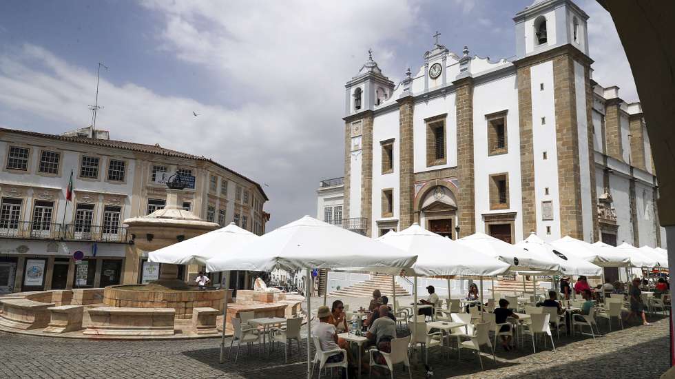 Populares refrescam-se numa esplanada da Praça do Giraldo, quando em Évora os termómetros ao final da manhã chegam aos 40 graus, 13 de julho de 2022. Devido a uma onda de calor em Portugal continental, que dura há vários dias, são esperadas temperaturas acima dos 45 graus em vários pontos do Alentejo e Ribatejo. NUNO VEIGA/LUSA